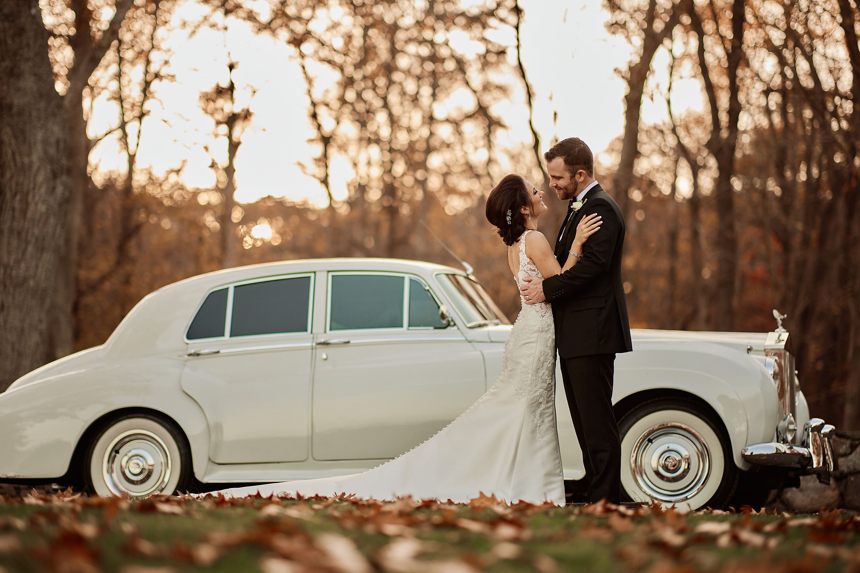 Couple posing with a classic white vintage car at sunset in Massachusetts